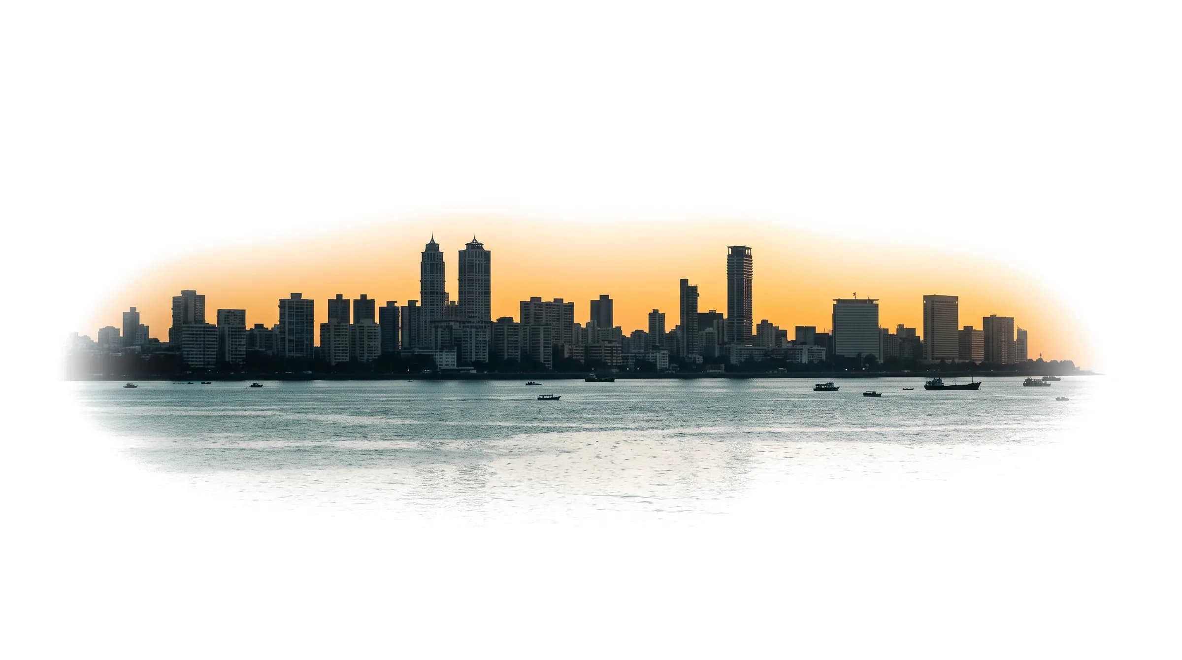 Mumbai skyline across the sea at dusk with a warm haze on the horizon